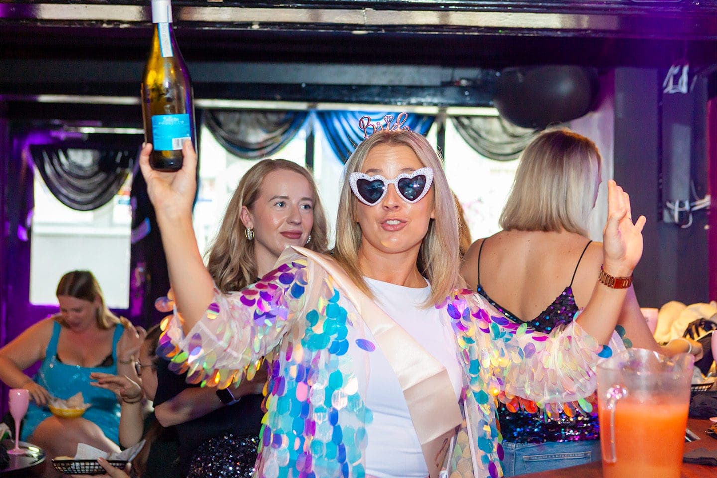 A bride-to-be holding up a bottle of bubbly