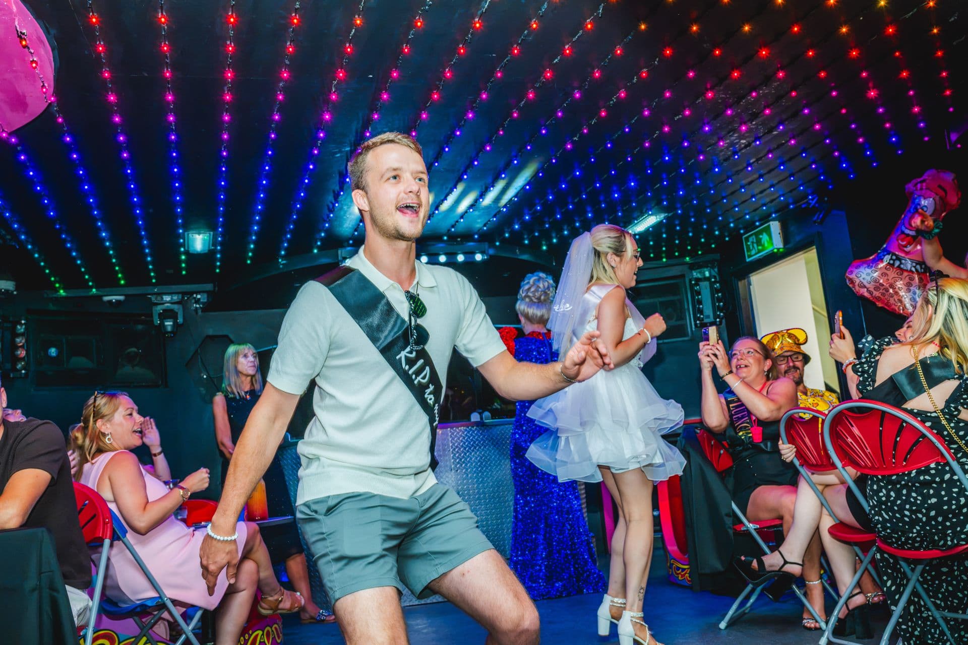 A groom-to-be in a sash dancing at a Qwerky drag brunch