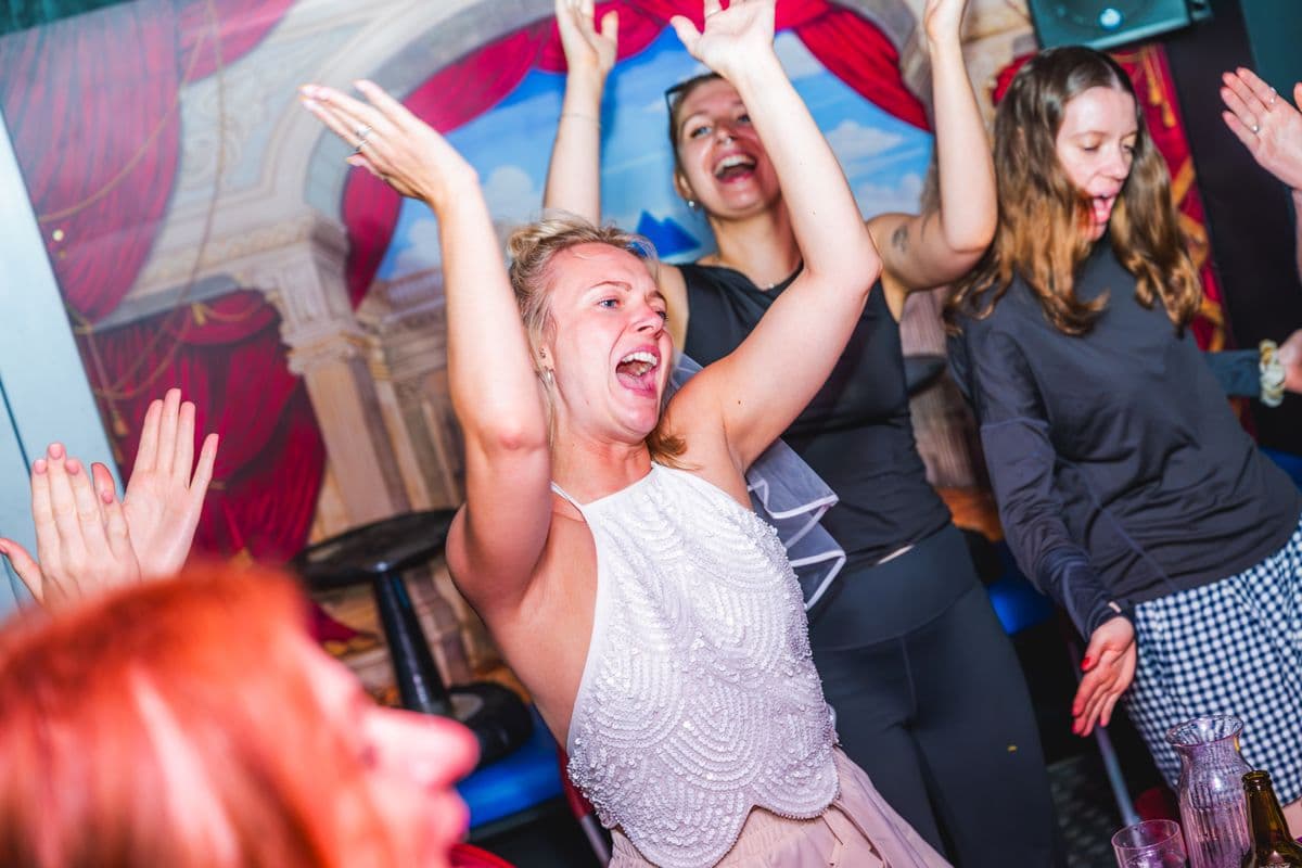 A guest dancing with her arms in the air