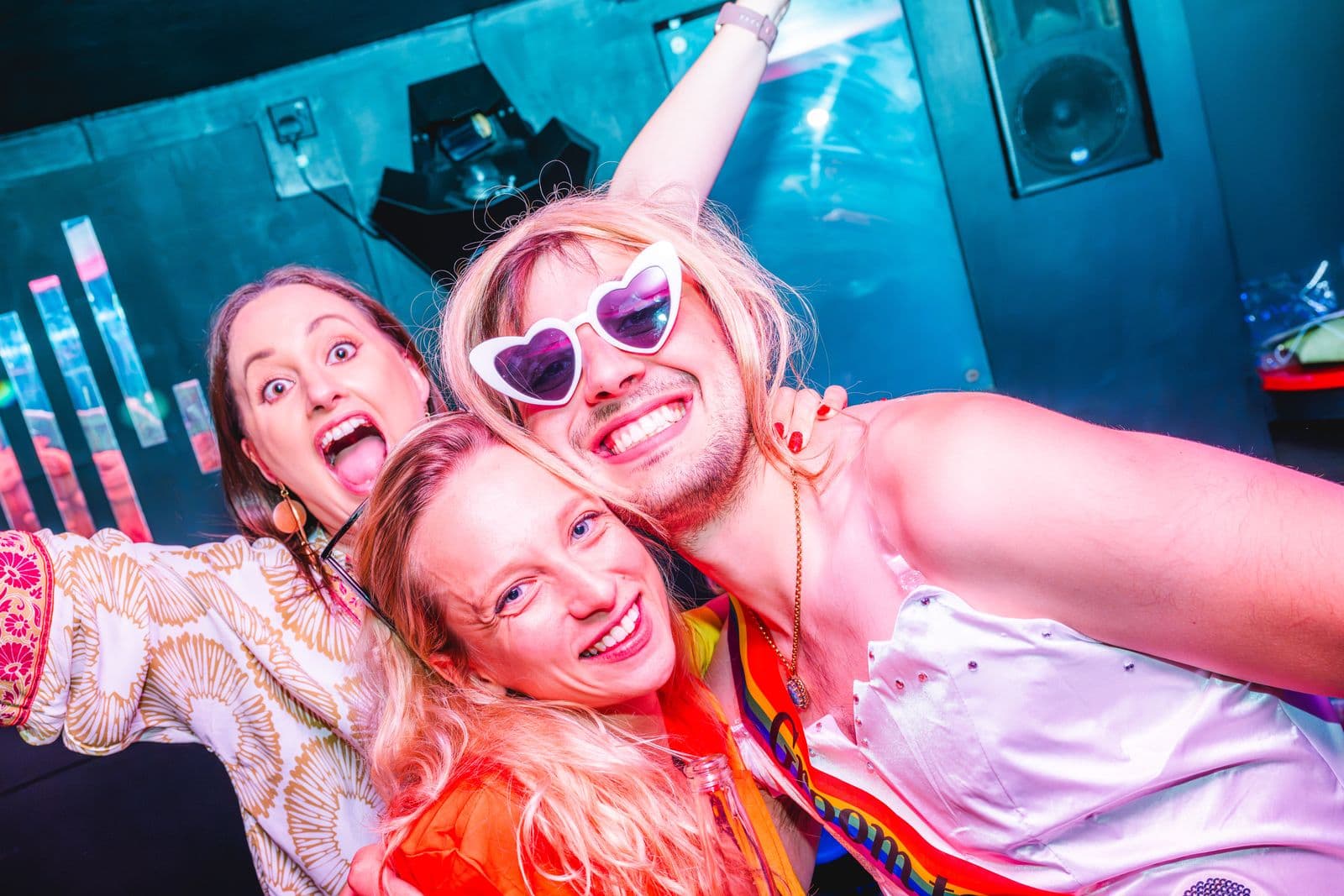 Friends in heart sunglasses pulling faces for a selfie