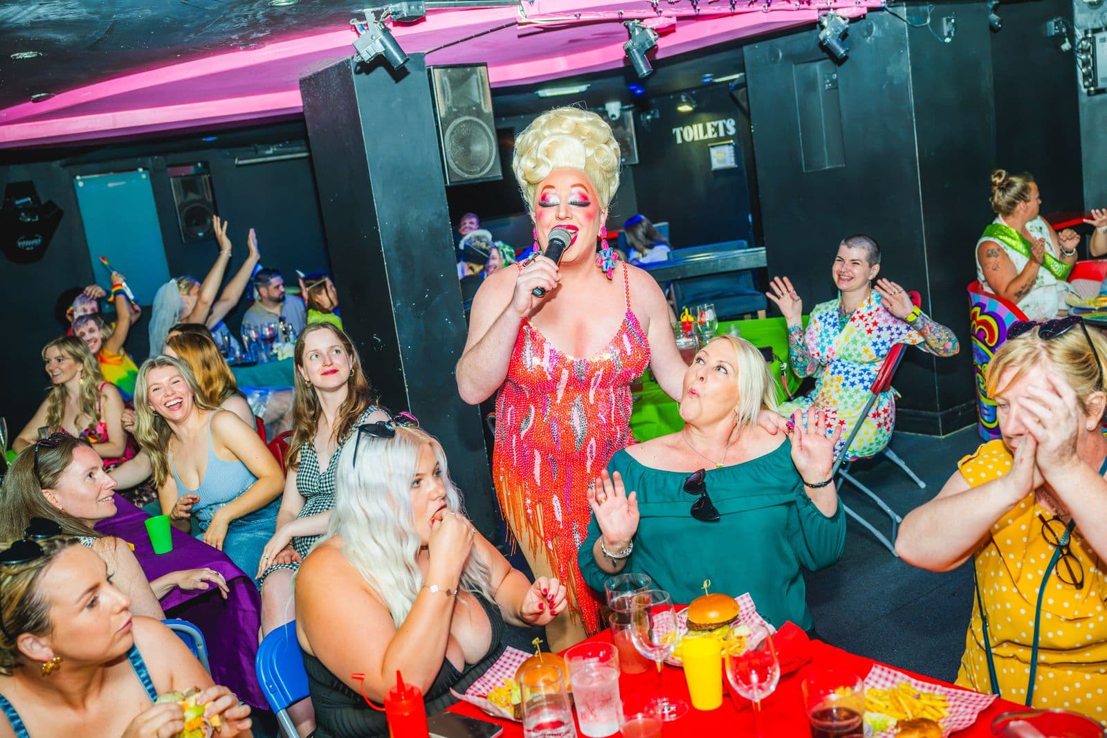 A drag queen singing among the brunch tables at Legends Brighton